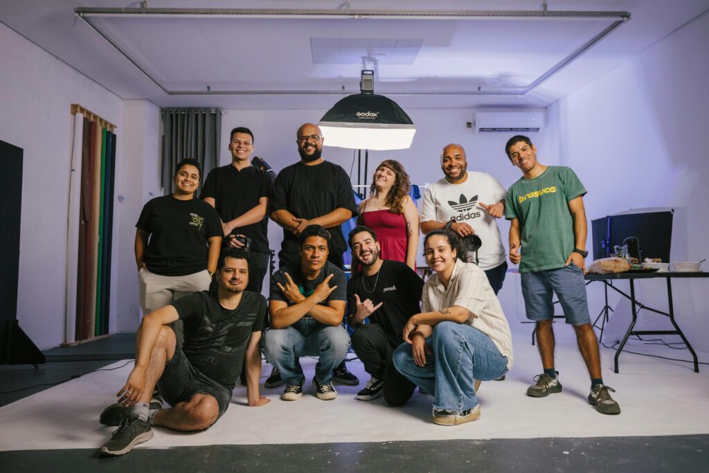 A diverse group of adults posing together in a professional photography studio, smiling and relaxed.