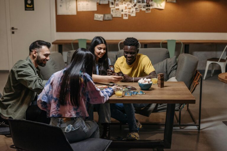 A group of friends enjoying a card game together in a cozy indoor setting, laughing and interacting.